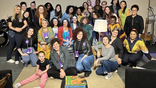 Foto de grupo do encontro em São Paulo, com as participantes sentadas e agachadas no tapete